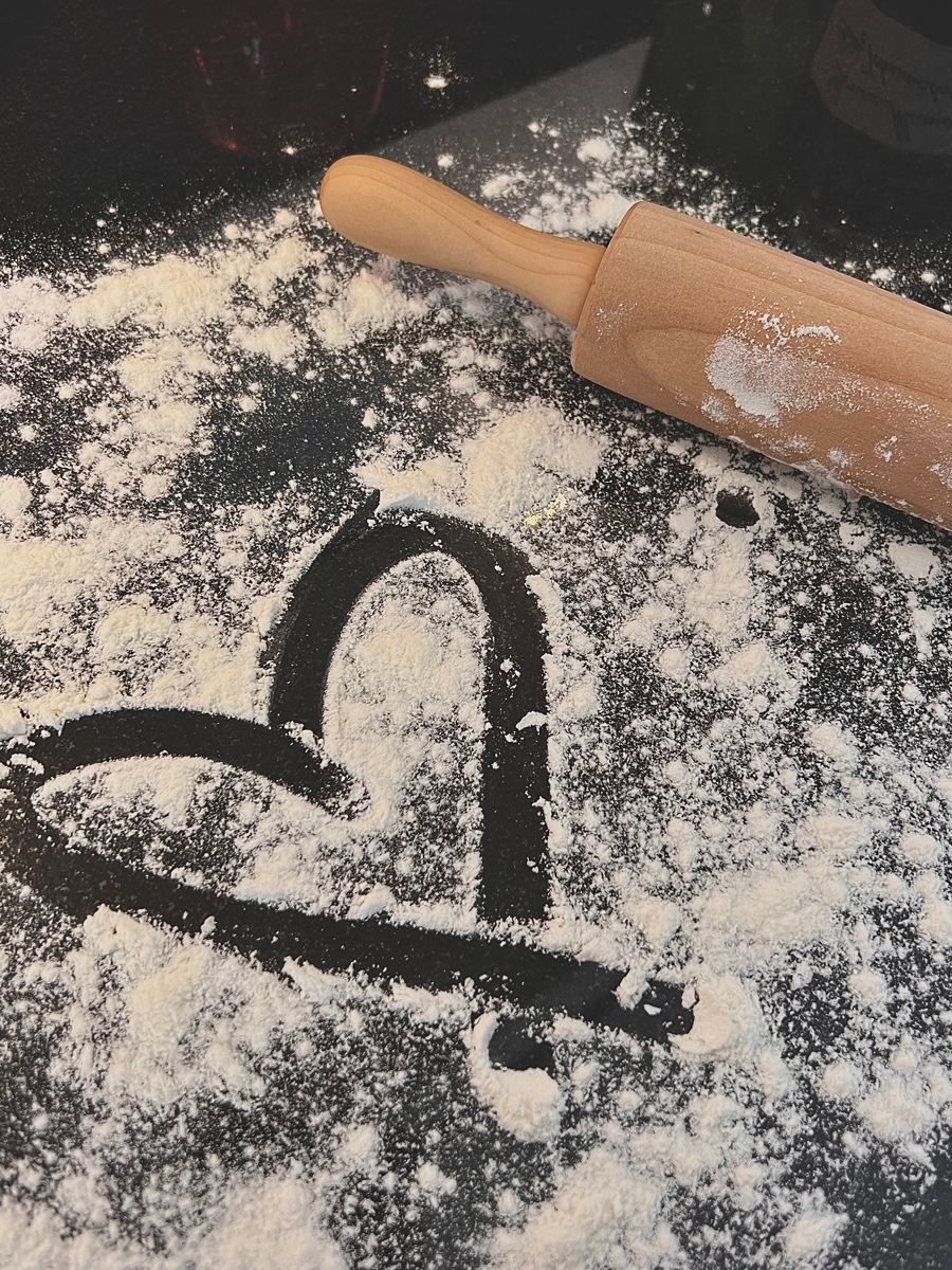 A heart drawn in flour next to a rolling pin