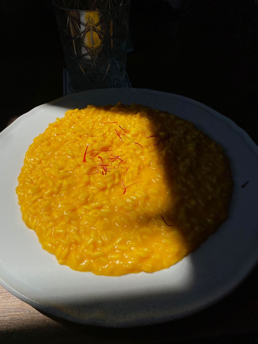A plate of saffron risotto in the sunlight